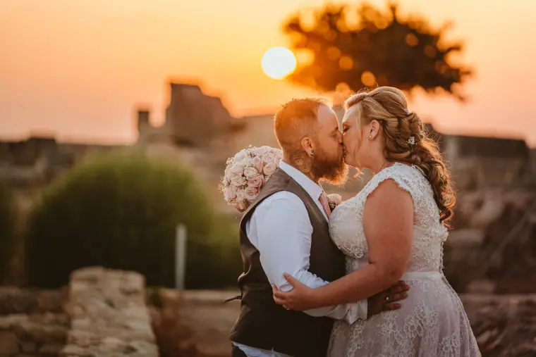 Jess and Andy kissing at sunset beside old stone walls at Liopetro, Kouklia