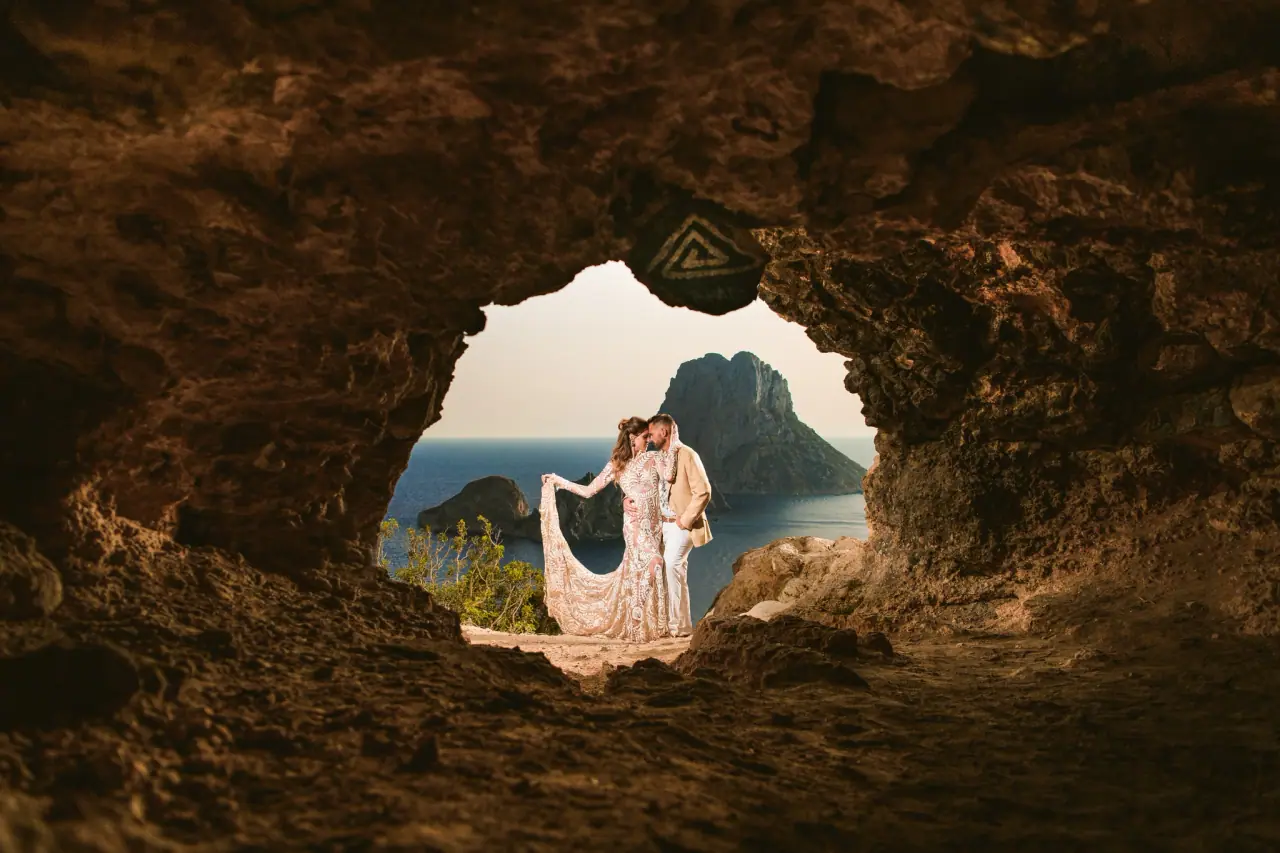 Kenton and Hassiba framed by a cave opening facing Es Vedrà, Ibiza