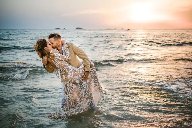 Kenton and Hassiba kissing in the shallows at sunset near Es Vedrà, Ibiza