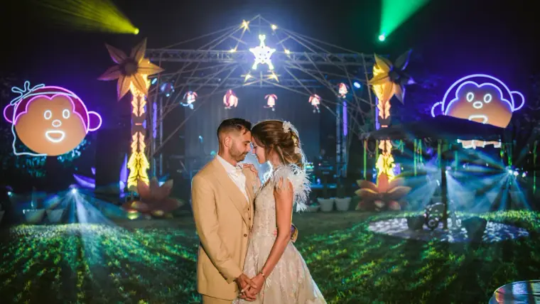 Kenton and Hassiba facing each other before a neon-lit festival stage at Kentiba Fest, Ibiza