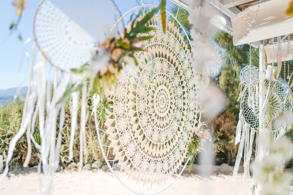 White crochet dreamcatchers hanging over the sand at a beach ceremony, Codolar, Salinas