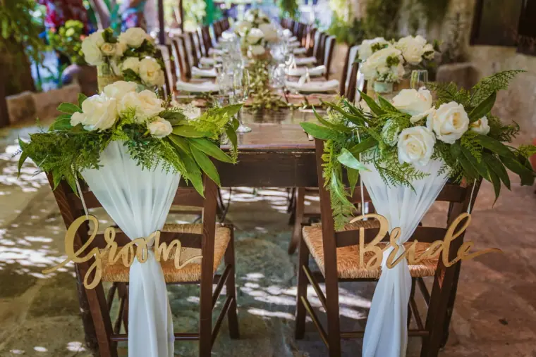 Groom and Bride chair signs with white roses and chiffon at a long table, Vasilias Inn, Kouklia