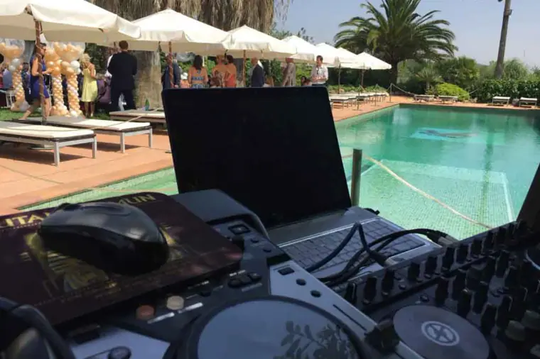 Laptop and DJ controller set up beside the pool at an Ibiza wedding reception