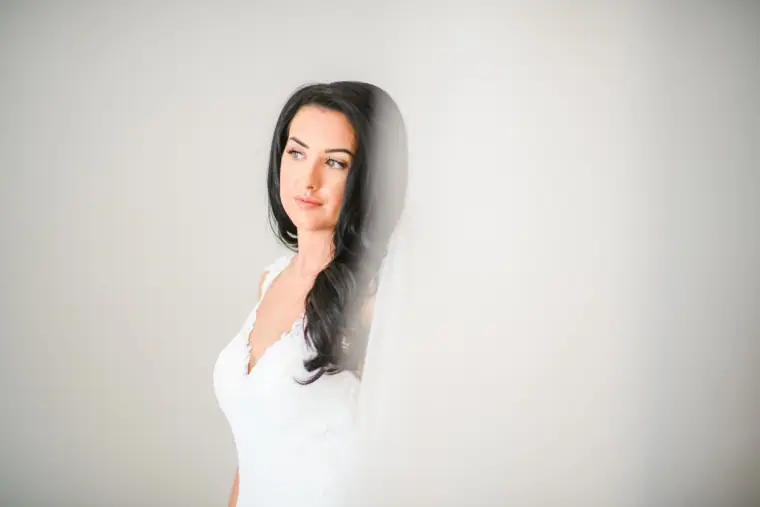 Jaclyn glancing over her shoulder in a lace-strap gown in soft window light