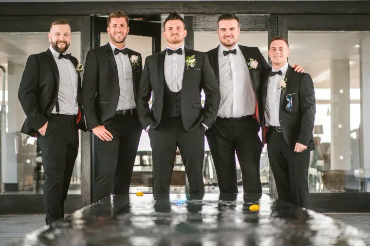 Steven and his groomsmen lined up in black tie in the Almyra lobby