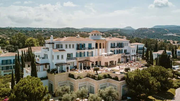 Drone view of the whitewashed Anassa Hotel buildings among cypress trees, Latchi