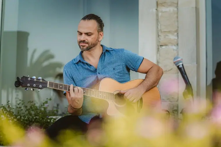 Guitarist playing acoustic guitar for the ceremony at Anassa Hotel, Latchi