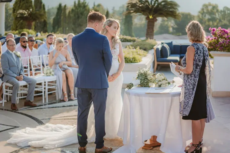 Carly and Jack before the celebrant at their seaside ceremony at Anassa Hotel