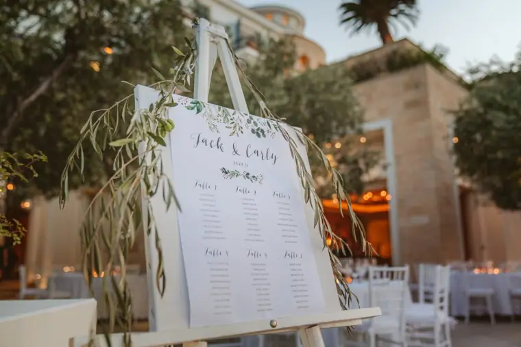 Olive-branch seating plan for Jack and Carly on an easel among the reception tables