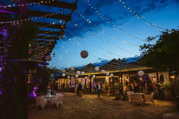 Courtyard at dusk strung with fairy lights and paper lanterns at Atzaro, Ibiza