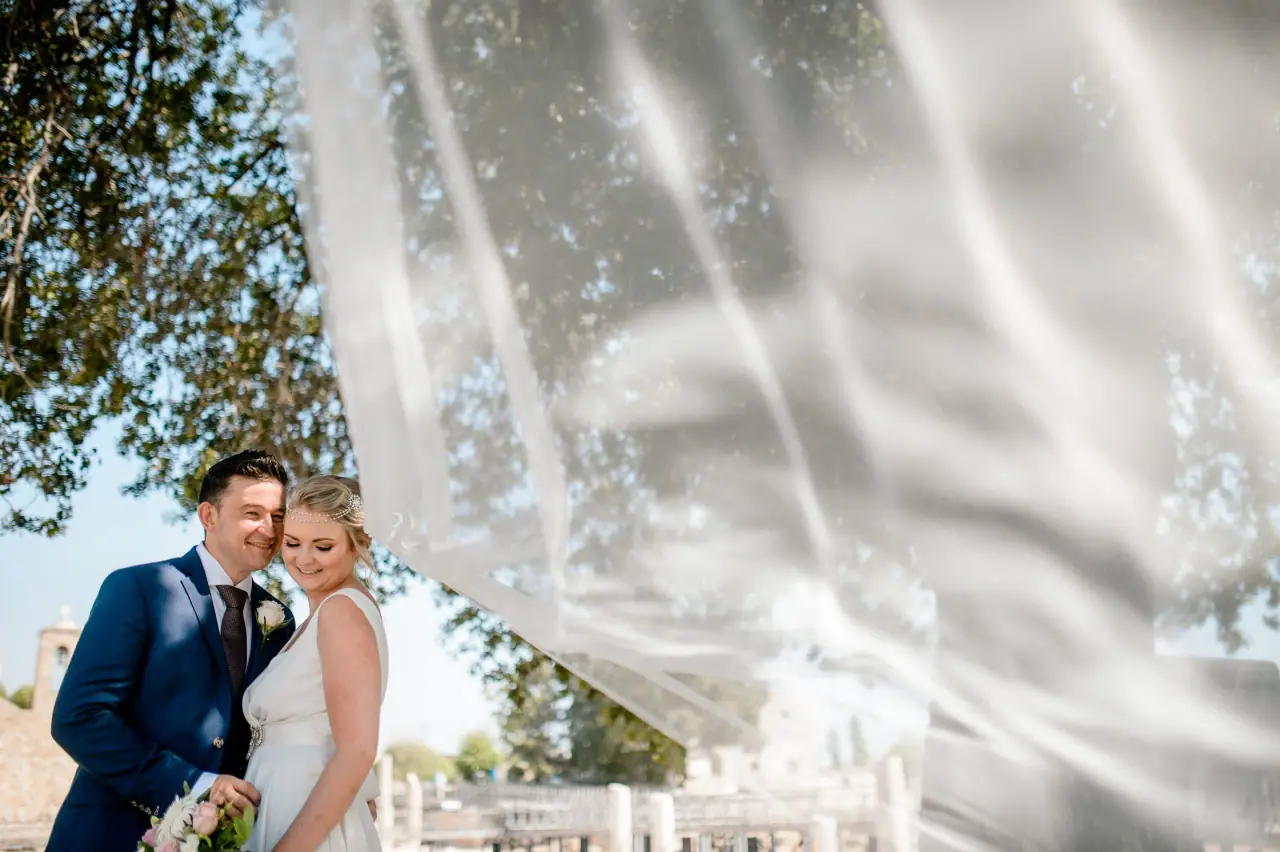 Francesca and Stephen framed by a drifting veil among the ruins at Ayia Kyriaki, Paphos