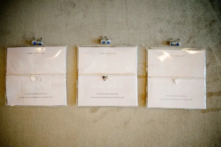 Three bracelet gifts on cards laid out for the bridesmaids