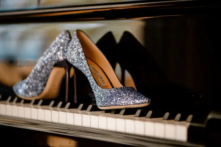 Silver glitter wedding heels displayed on piano keys