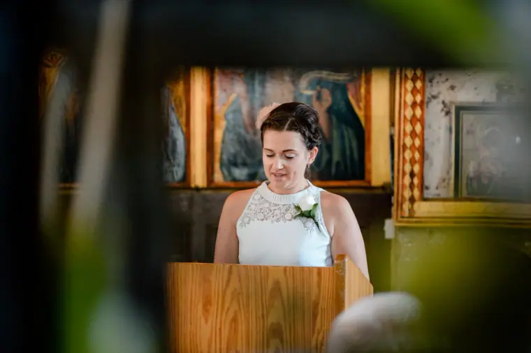 Guest giving a reading at a wooden lectern inside Ayia Kyriaki church, Paphos