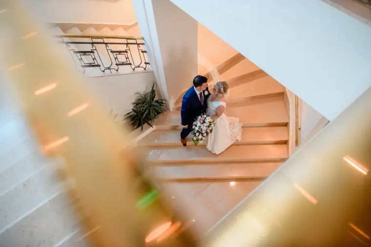 Bride and groom sitting on a spiral staircase, seen from above