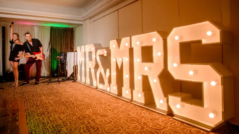 Light-up MR & MRS letters in the reception room as guests dance