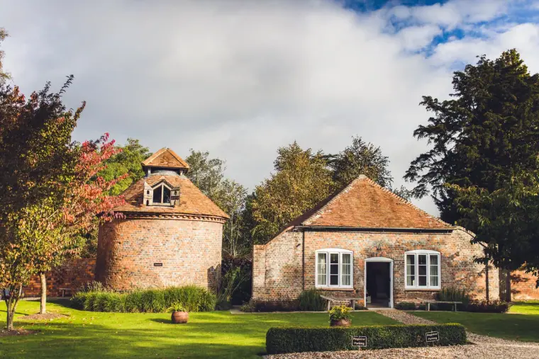 Brick dovecote and cottage set on a neat lawn at Wasing Park