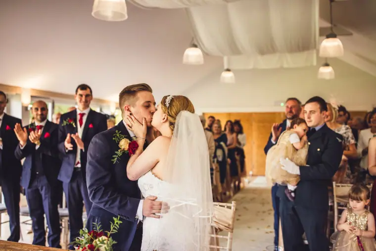 Sarah and Charlie sharing their first kiss as guests applaud