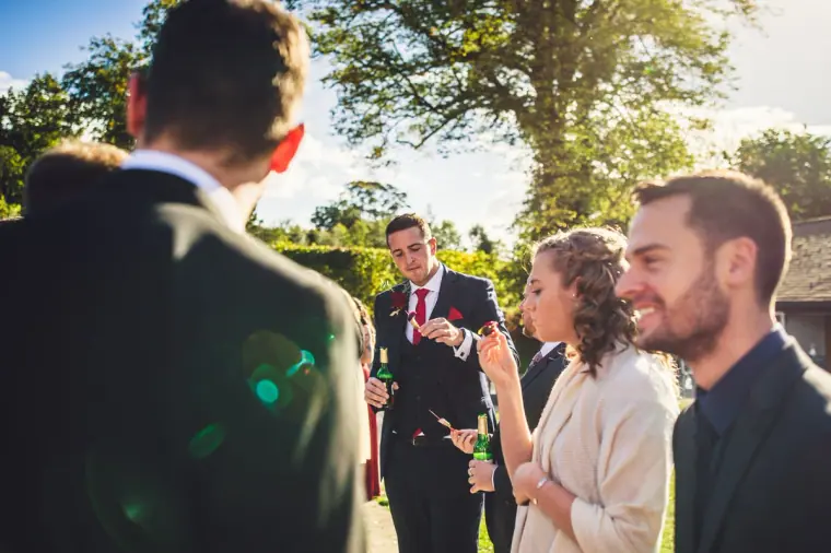 Guests laughing together in the sunshine during the drinks reception