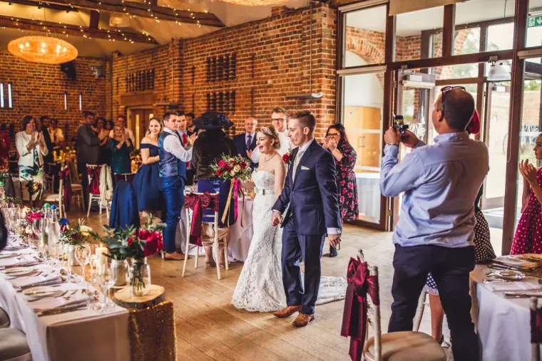 Sarah and Charlie entering the dinner as guests stand and cheer