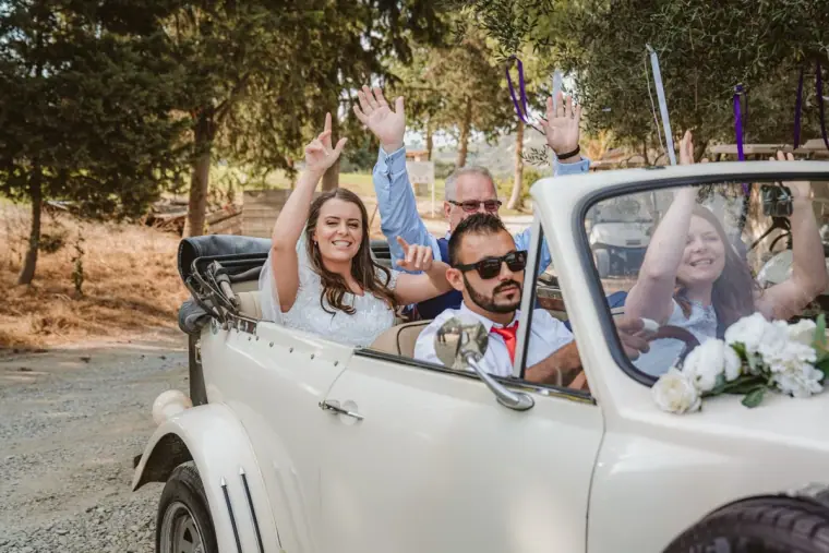 Emily and Liam waving from a white vintage convertible, Minthis, Paphos