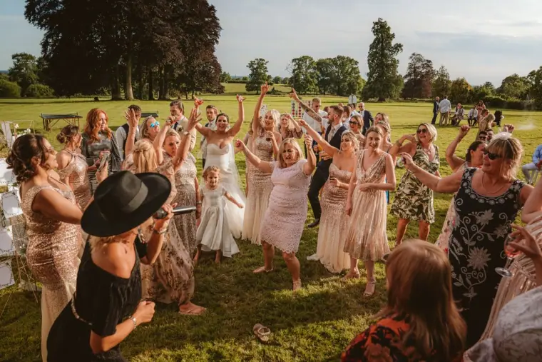 Guests dancing with arms raised on the lawn at Château de la Basmaignée, France