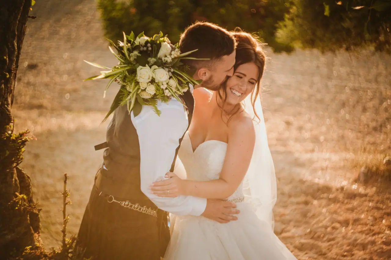Keith kissing Hannah's cheek as she laughs in golden evening light at Vasilias Nikoklis Inn, Paphos