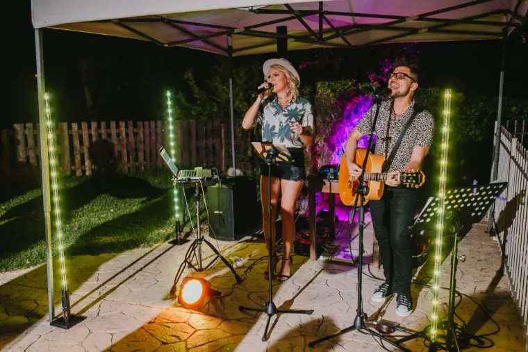 Acoustic duo singing under a lit gazebo at an evening reception at Vasilias Nikoklis Inn