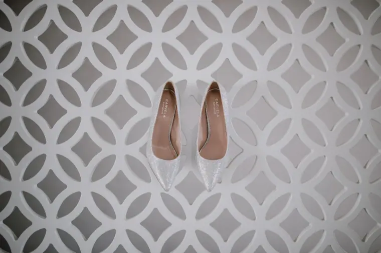 Pair of nude bridal heels on a white lattice-patterned floor in Santorini