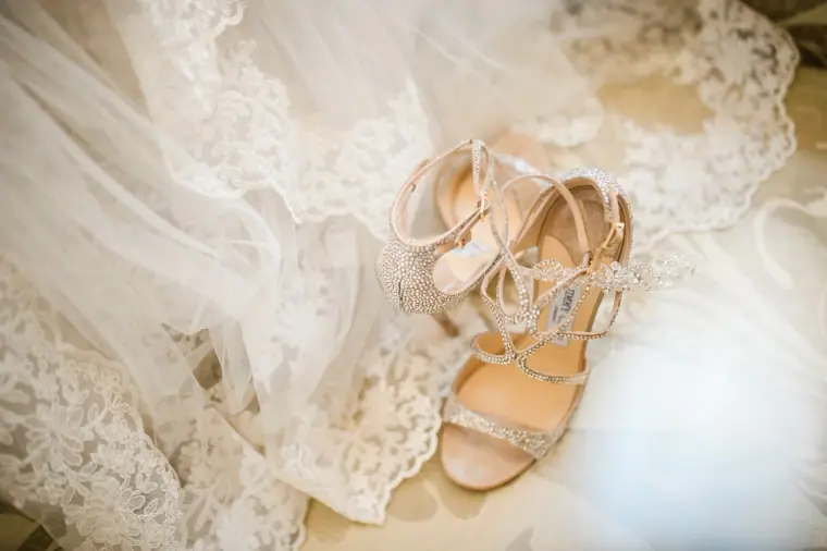 Sparkly strappy bridal sandals resting on lace at Anassa, Cyprus