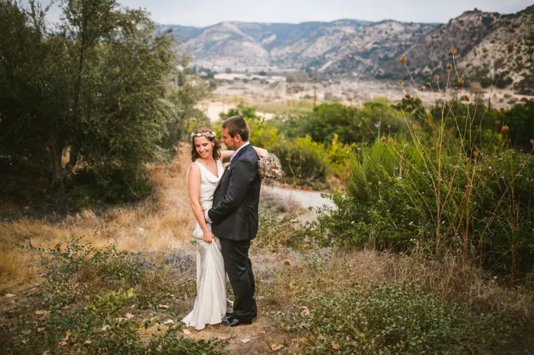 Kazem and Fleur standing on a hillside path with mountains behind, near Vasilias Nikoklis Inn