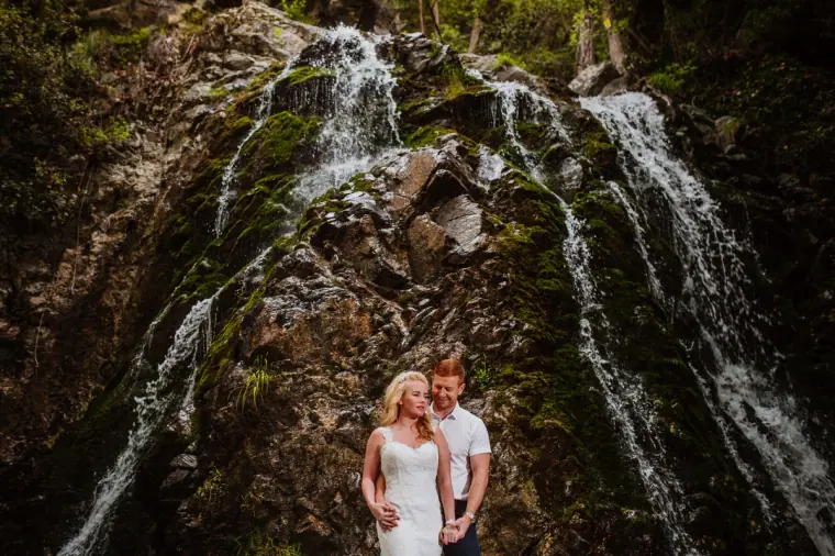 Couple posing before a cascading waterfall in the Troodos Mountains