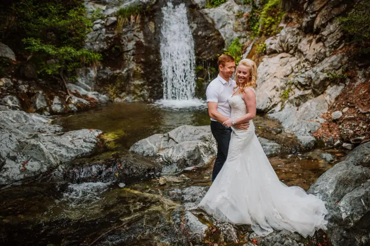 Couple embracing beside a waterfall and rock pool in the Troodos Mountains