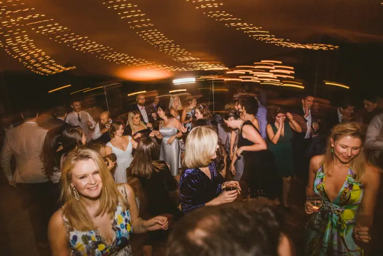 Guests dancing under ceiling fairy lights at Nermine and Chris's reception, Lexeko Estate
