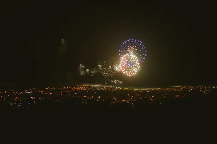Fireworks bursting over glittering city lights at night, seen from a villa in Paphos
