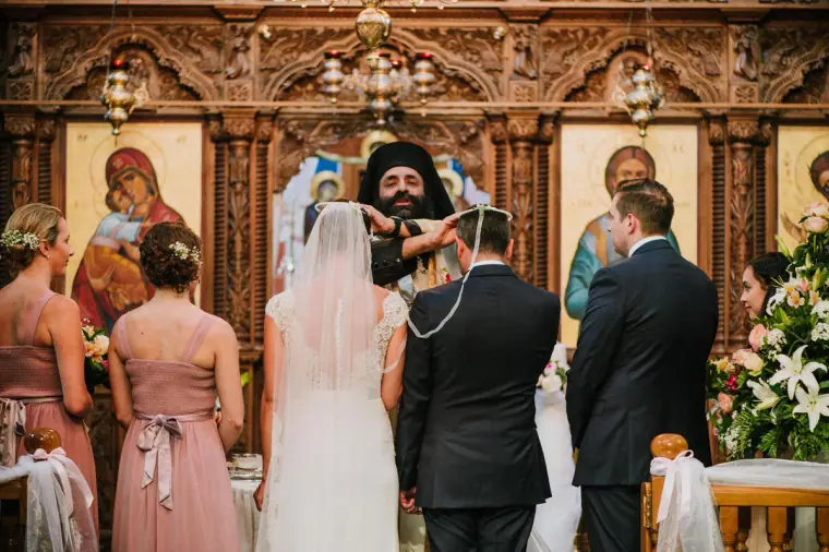 Orthodox wedding ceremony before a carved iconostasis at Hadjiantonas Winery, Limassol