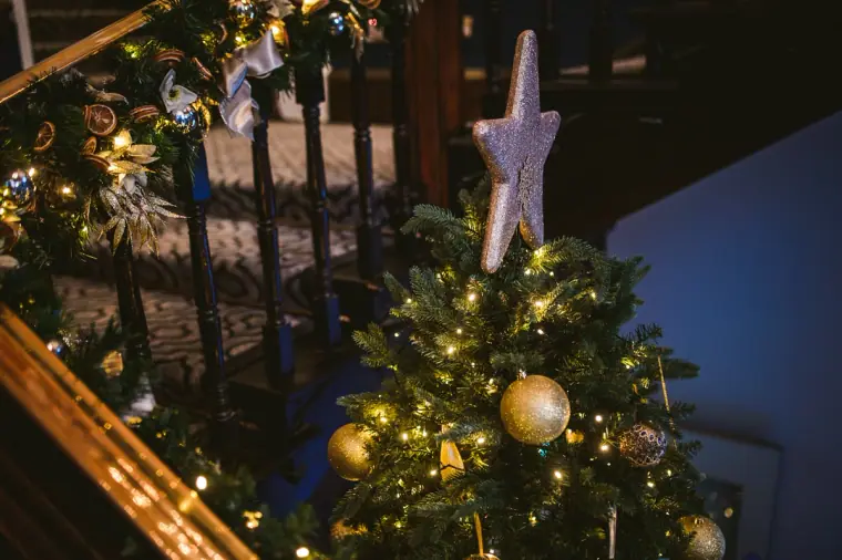 Christmas tree with gold baubles and a star topper at Wotton House, Surrey