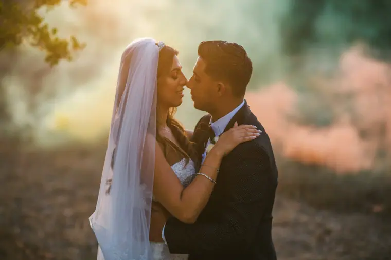 Couple embracing nose to nose in soft hazy light at Anassa, Cyprus