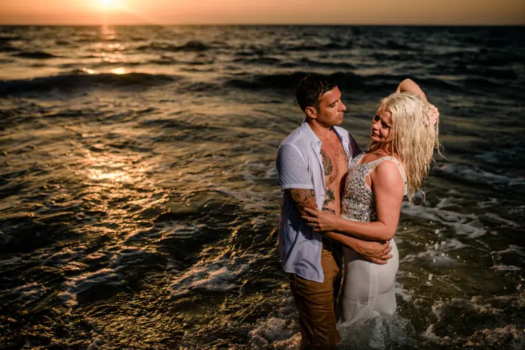 Maryellen and Ben embracing waist-deep in the sea at sunset, Paphos