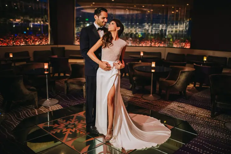 Bride in a high-slit gown with the groom in a dark lounge bar, Four Seasons Limassol