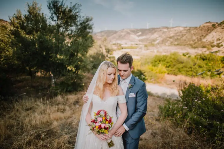 Stephanie and Jack in the hills near Vasilias Nikoklis Inn, she holds a bright bouquet