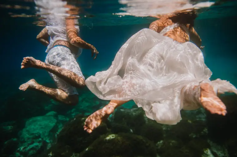 Underwater trash-the-dress shot of a couple swimming, her gown billowing, Cyprus