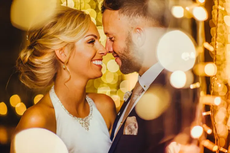 Couple nose to nose surrounded by twinkling golden bokeh, Edinburgh