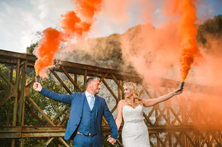Brooke and Wayne on a wooden bridge holding orange smoke flares aloft, Troodos