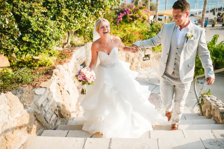 Charlotte and Nathan walking hand in hand up stone steps at Coral Beach Hotel, Paphos