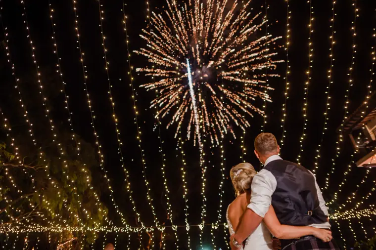Nicole and Craig watching fireworks beneath curtains of fairy lights, Hadjiantonas Winery