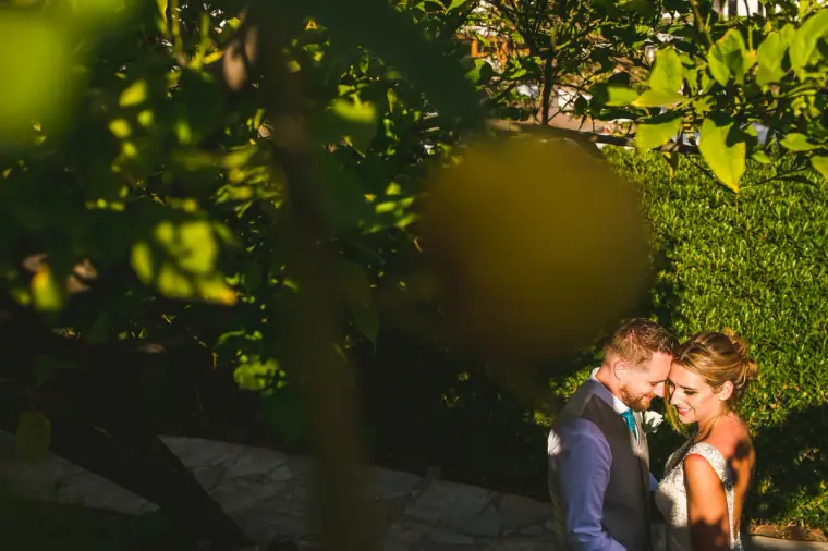 Couple touching foreheads, framed by deep green foliage, Annabelle, Paphos