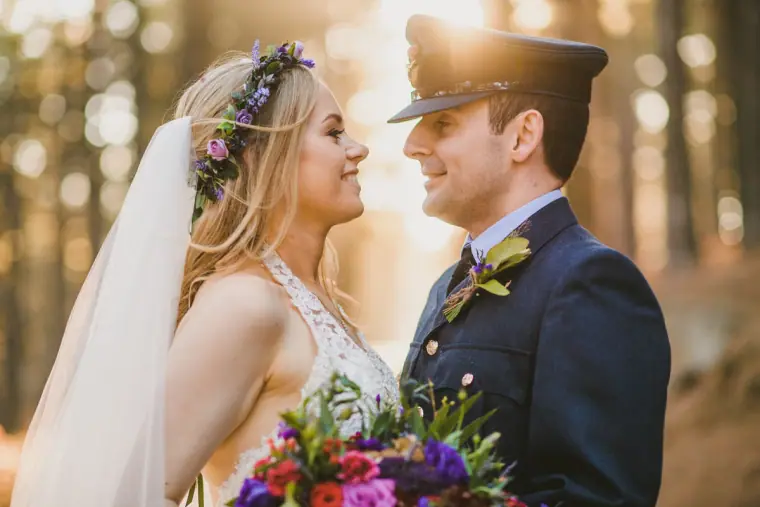 Steph in a flower crown smiling at Alasdair in his RAF uniform in a sunlit Troodos forest
