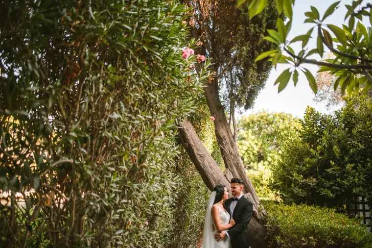 Jaclyn and Steven tucked among lush trees and hedges in the gardens at Almyra, Paphos