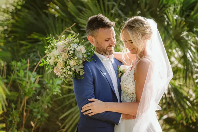 Iain holding Sophie and her bouquet among palm fronds at Can Gall, Ibiza